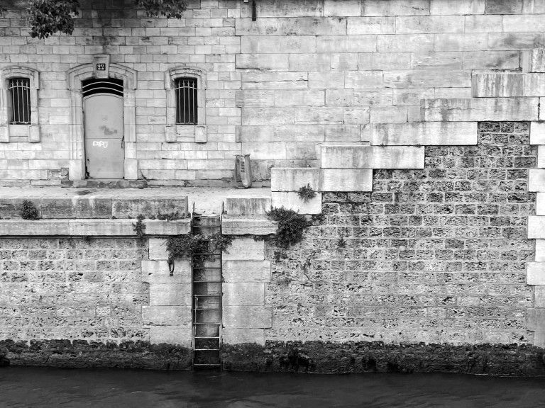 Stone steps and an arched opening beside still water.