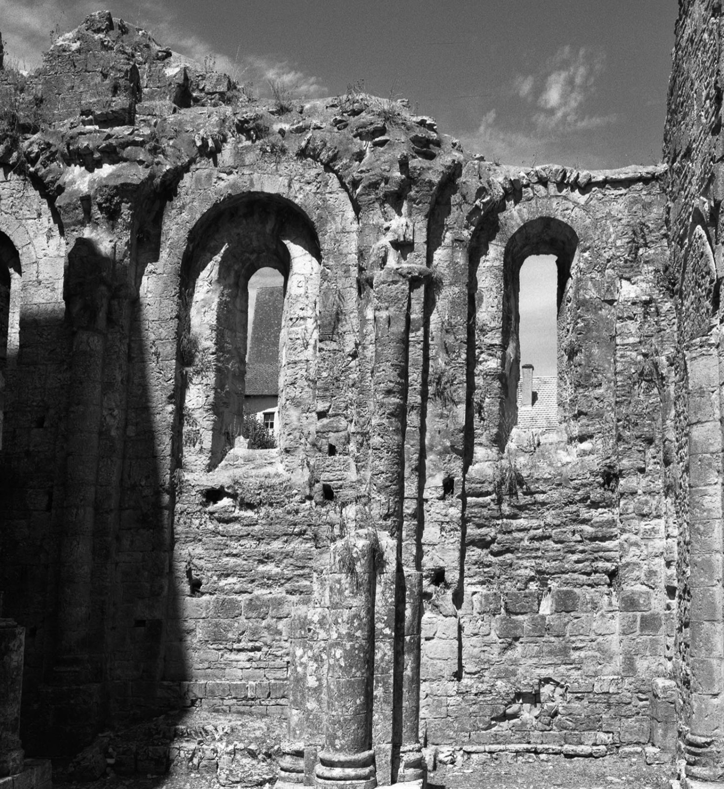 Arched stone ruins standing against a cloudy sky.